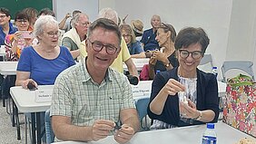 Menschen sitzen an Schultischen